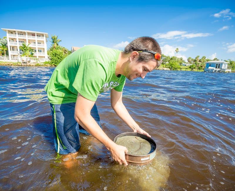 A student collecting samples in the Indian River Lagoon